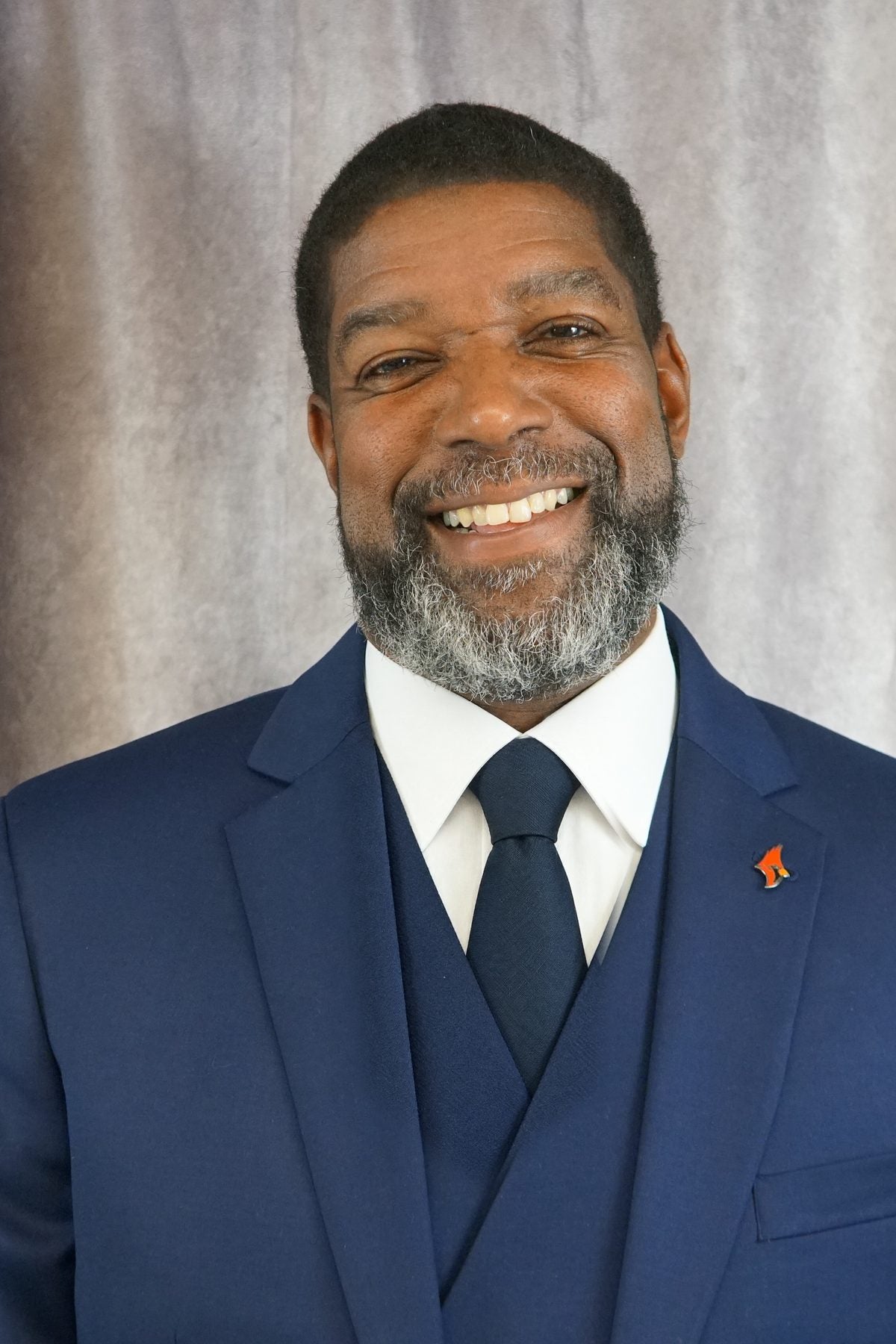 Dr. Henry Pettiegrew II, smiling, in a navy suit